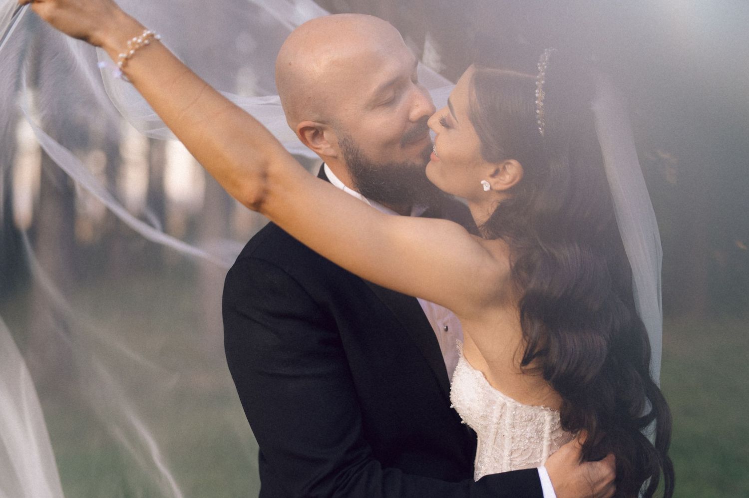 A couple in formal attire dances together in an elegant ballroom setting with soft lighting and romantic atmosphere.