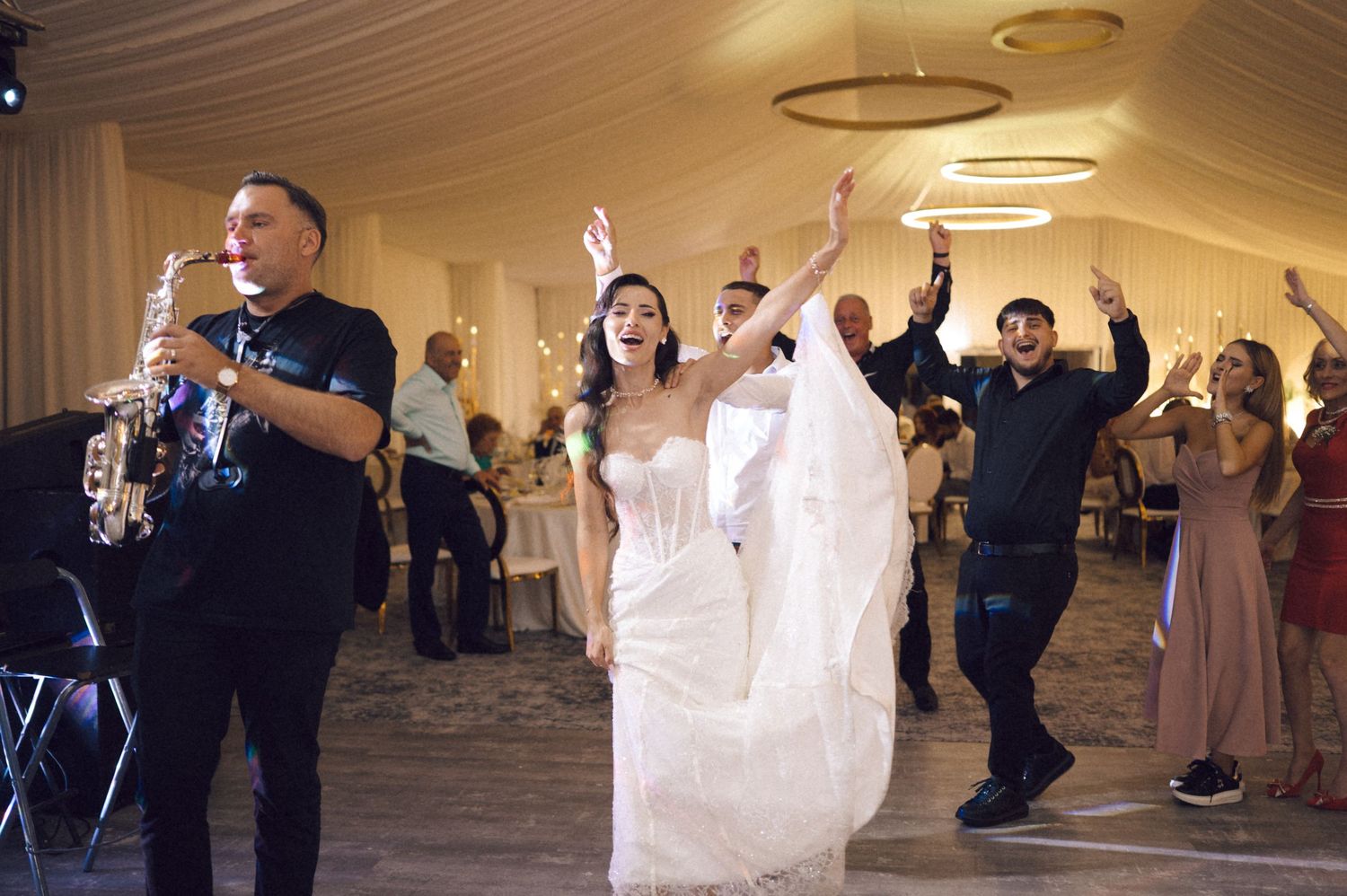 A sequence of dance floor photos showing wedding guests celebrating and dancing at an elegant indoor reception.