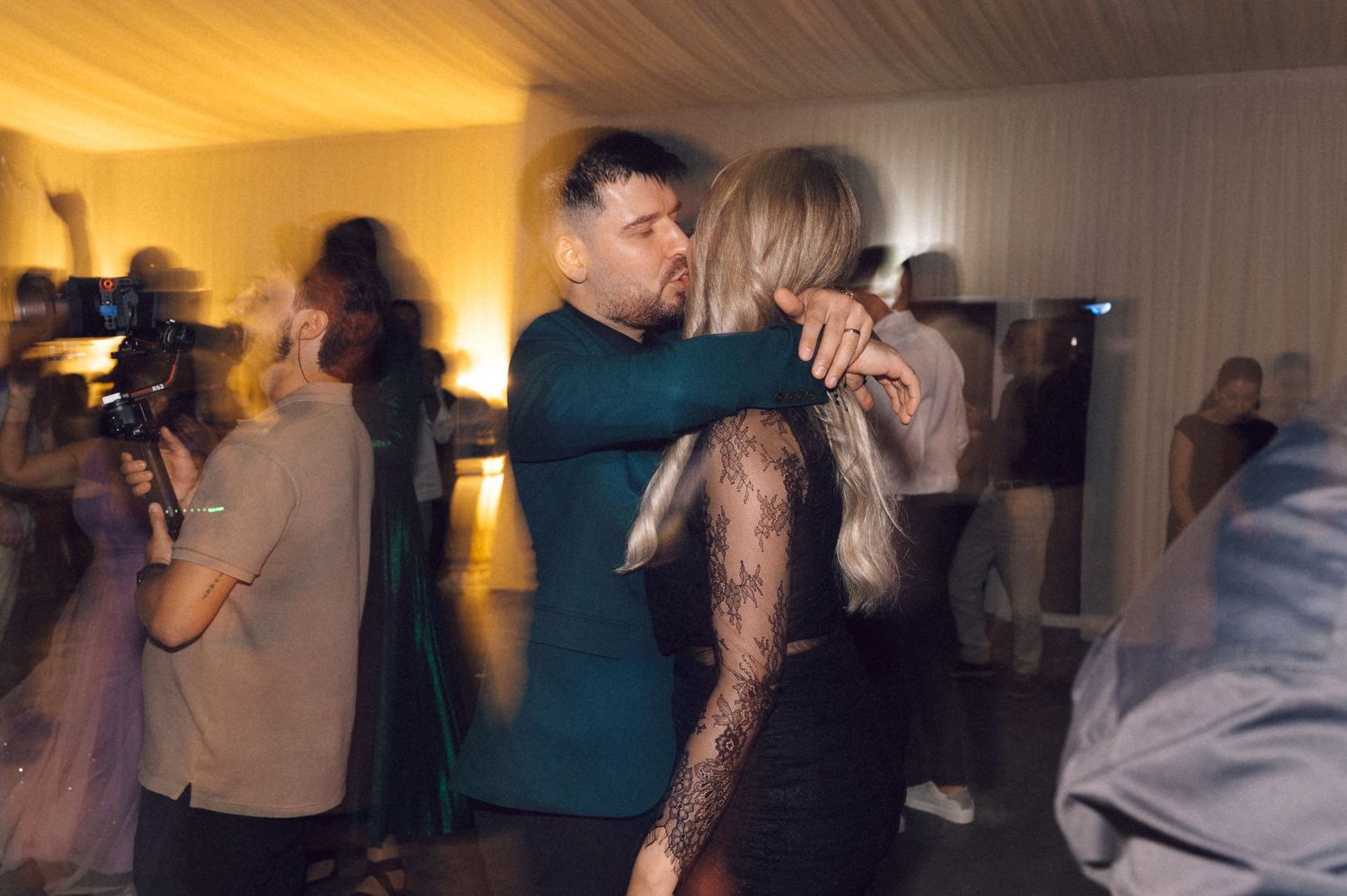 People dancing in a dimly lit room during a celebration or party event.