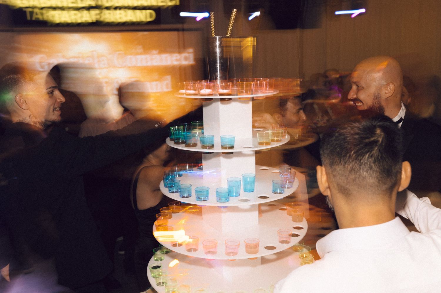 A blurred motion sequence of a glowing birthday cake with lit candles being carried in a dark room.
