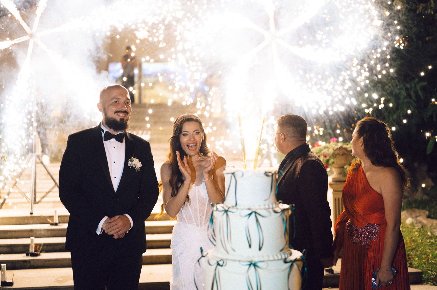A collage of wedding celebration moments with sparklers glowing in the background during an evening reception.