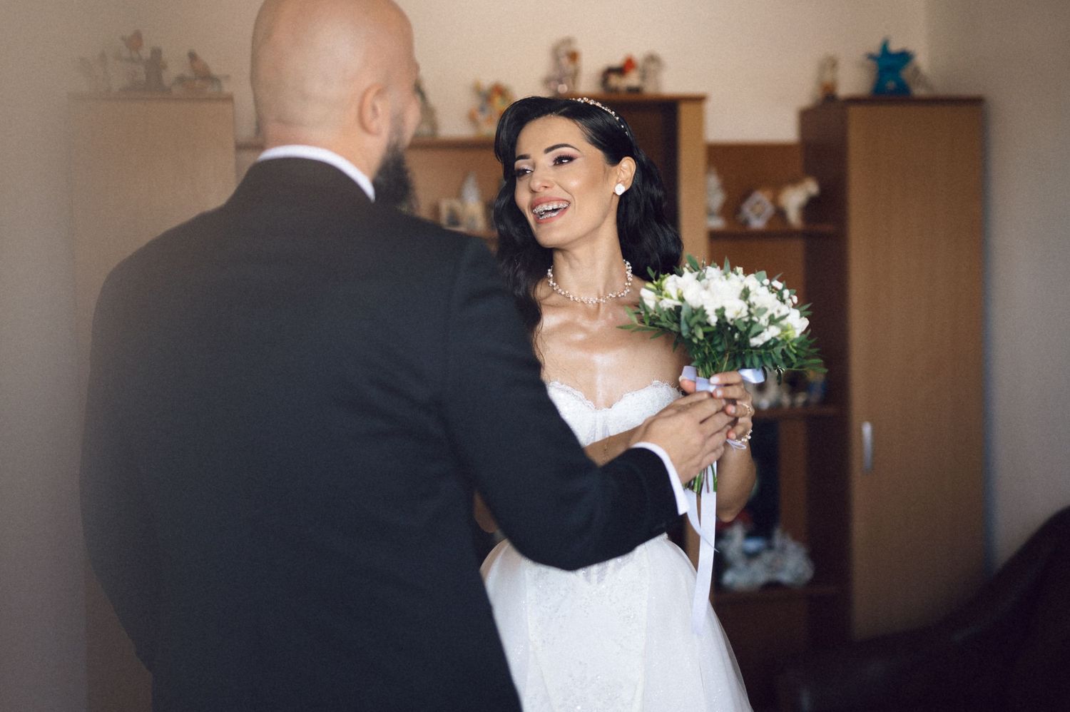 A couple in wedding attire embraces during a romantic first dance moment at their reception.