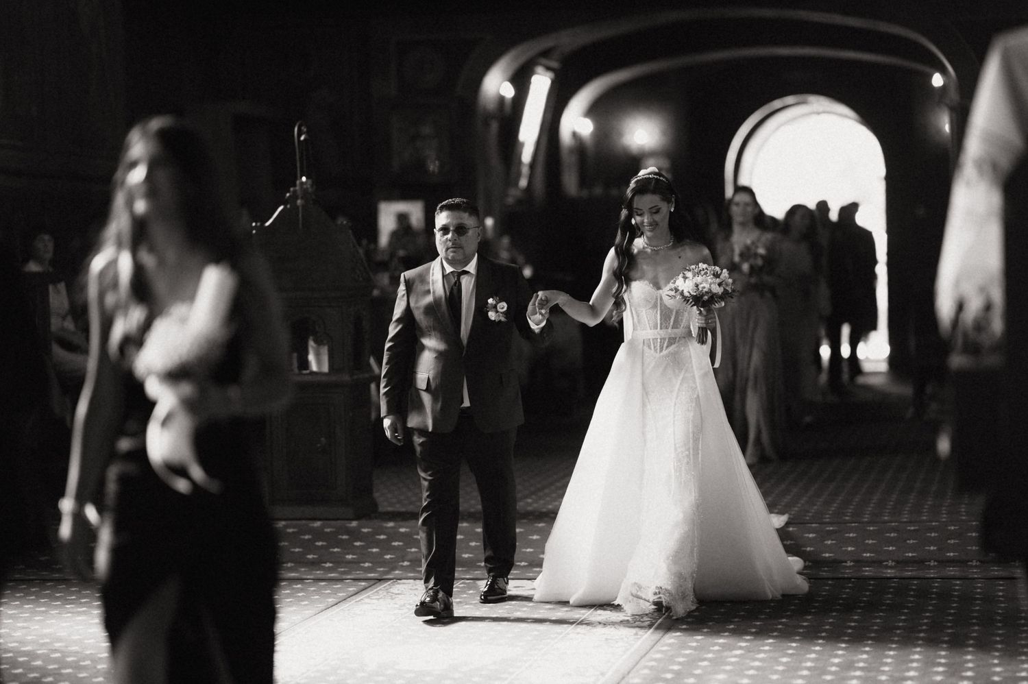 Wedding guests dance and celebrate on a dark dance floor during an evening reception celebration.