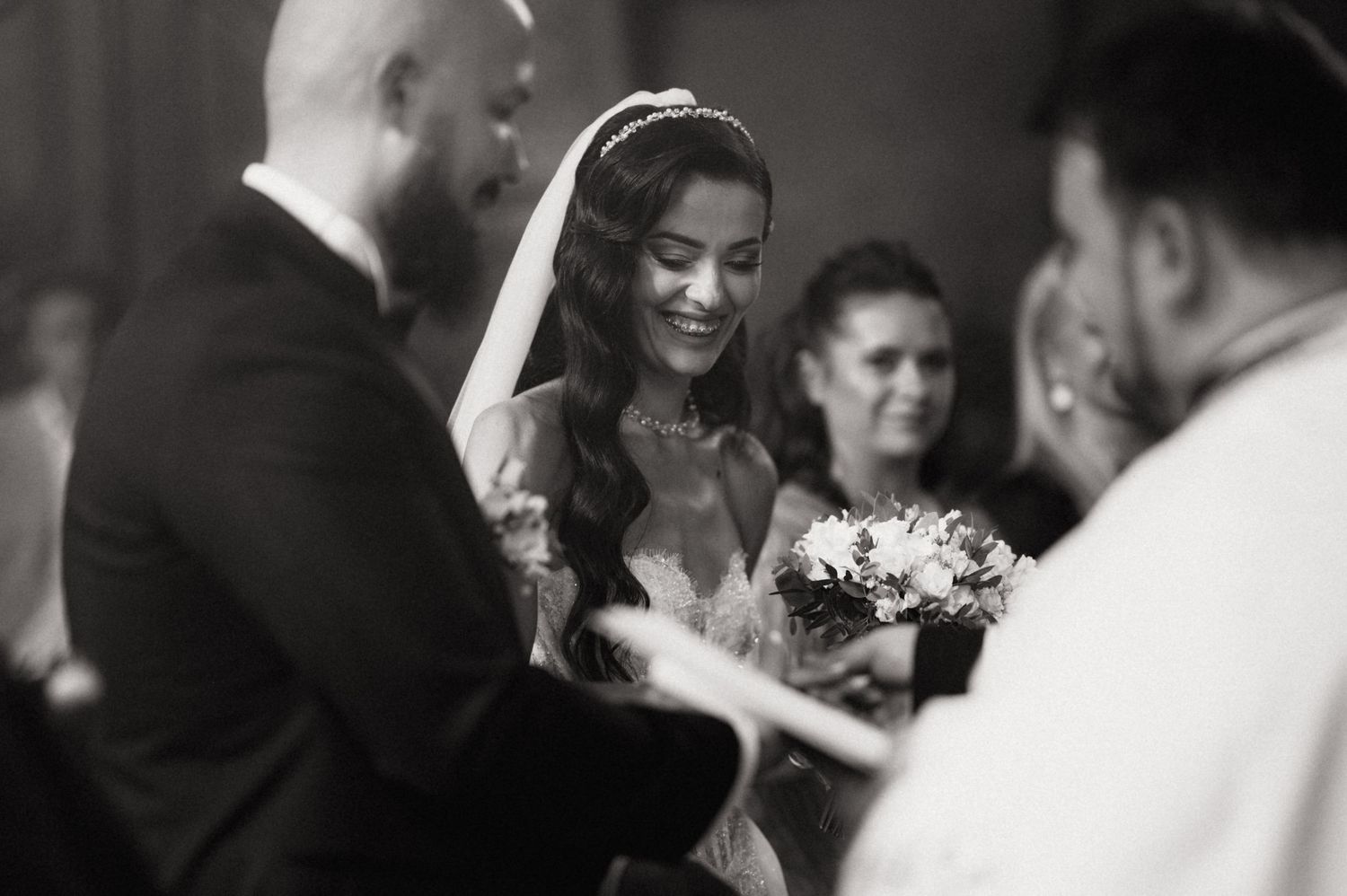 A series of black and white wedding photos showing emotional candid moments during a ceremony.