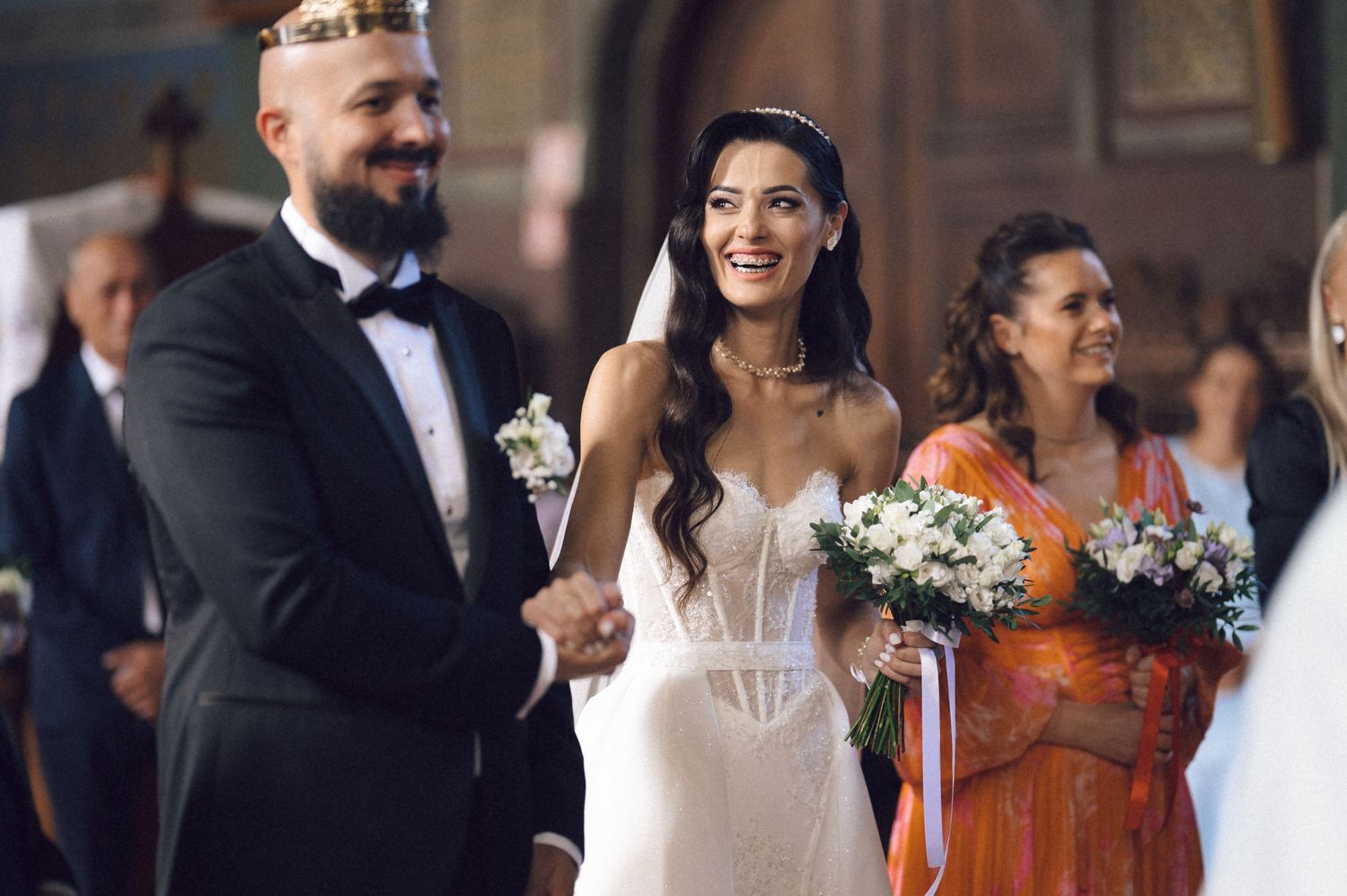 Wedding guests share joyful moments and laughter during an indoor celebration.