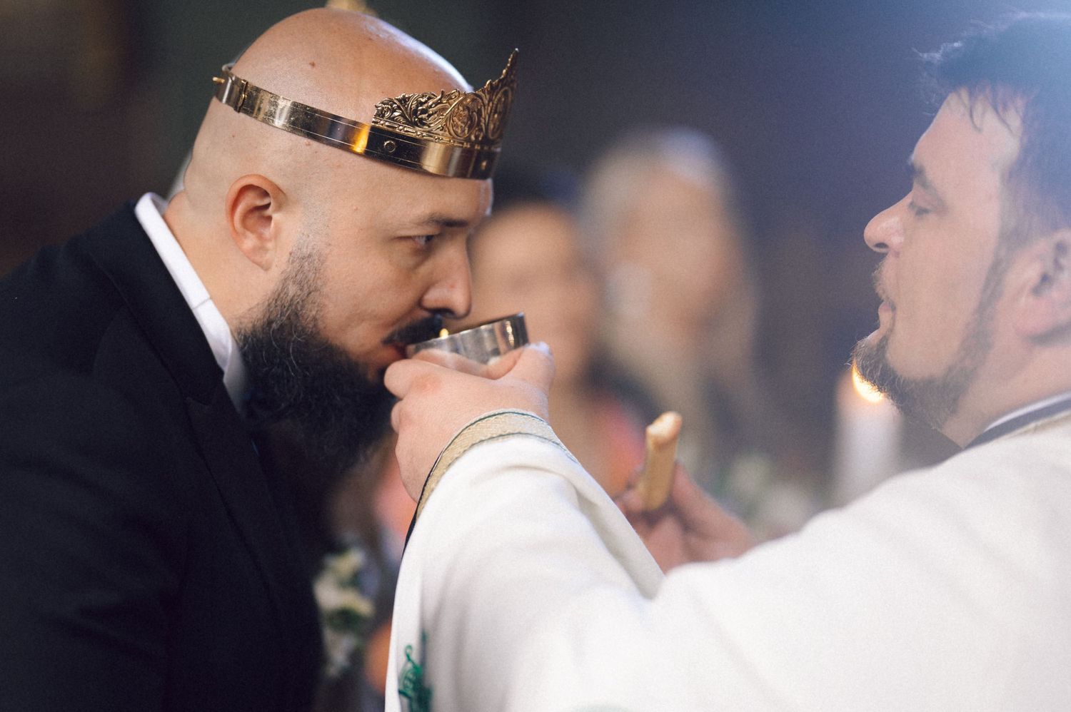 Two people in formal attire share an intimate moment during what appears to be a wedding celebration.