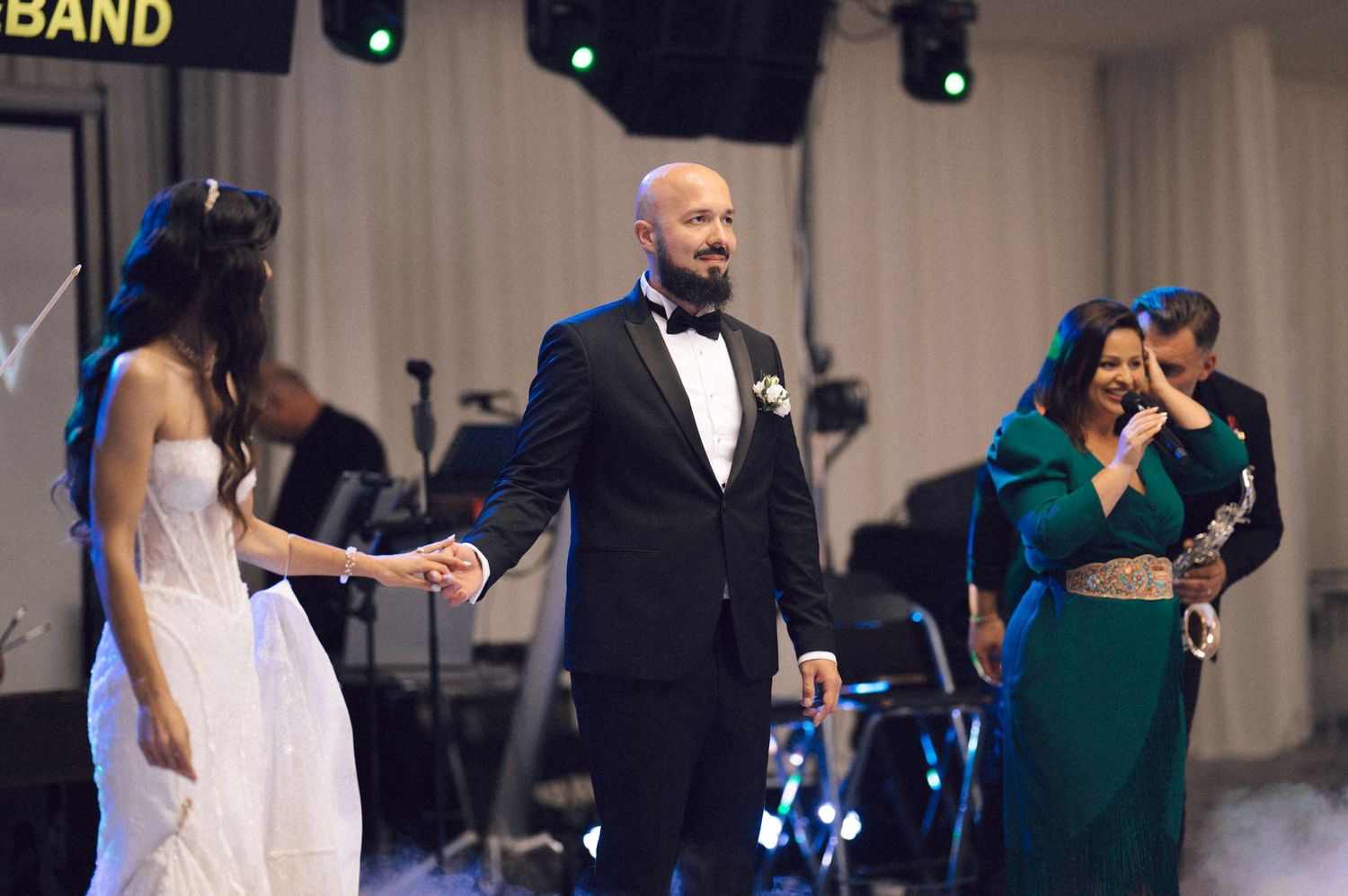 Wedding band performs on stage during reception while guests dance on the dance floor.