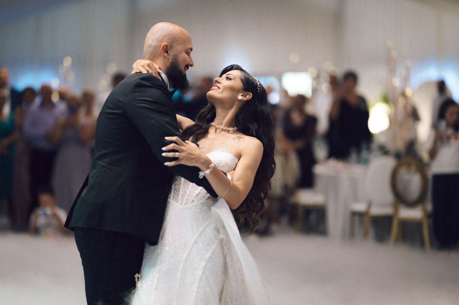 A joyful couple shares their first dance at their wedding reception in an elegant venue.