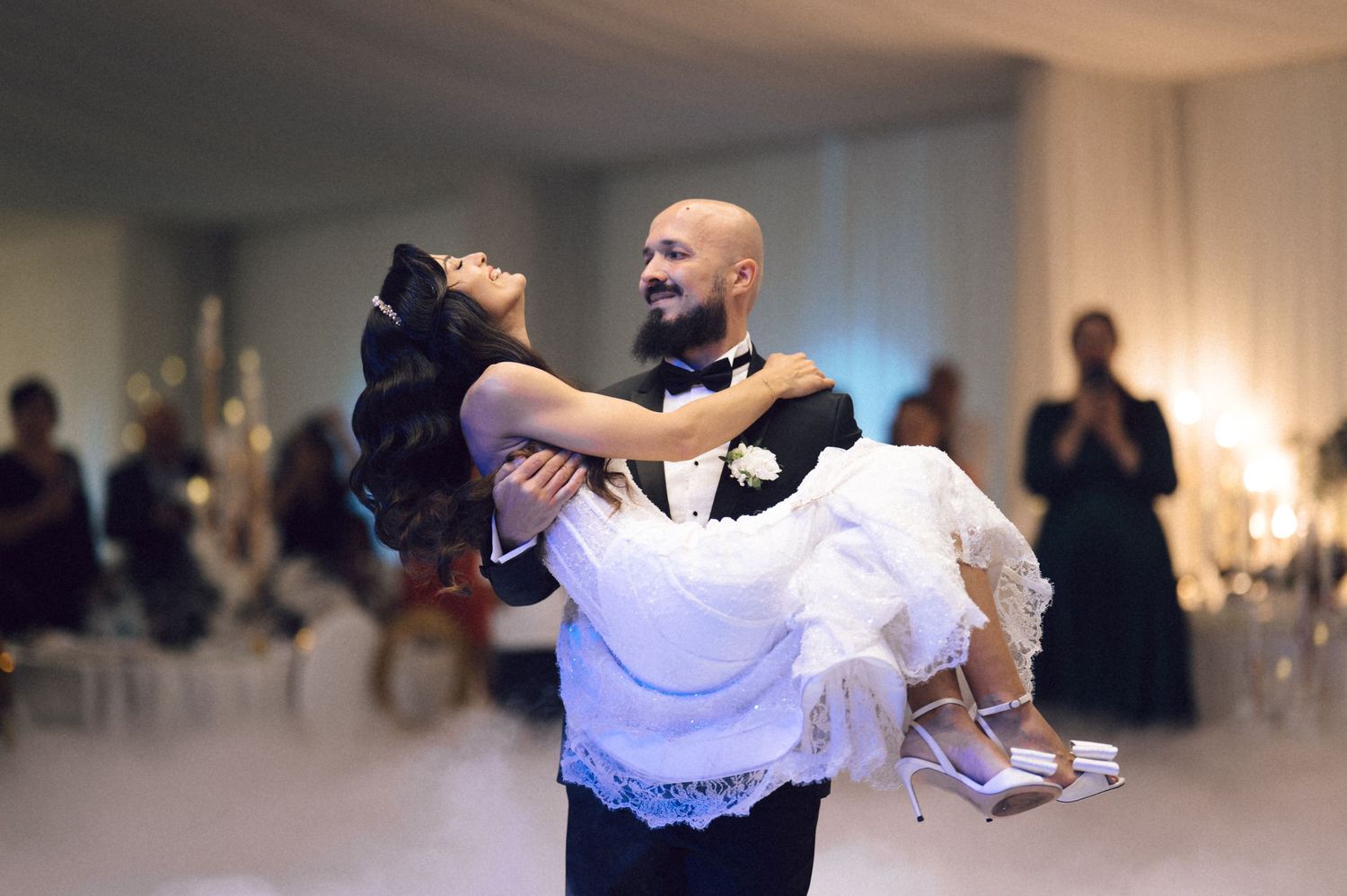 Couples dance together at a formal ballroom event, practicing elegant dance moves in an indoor venue.