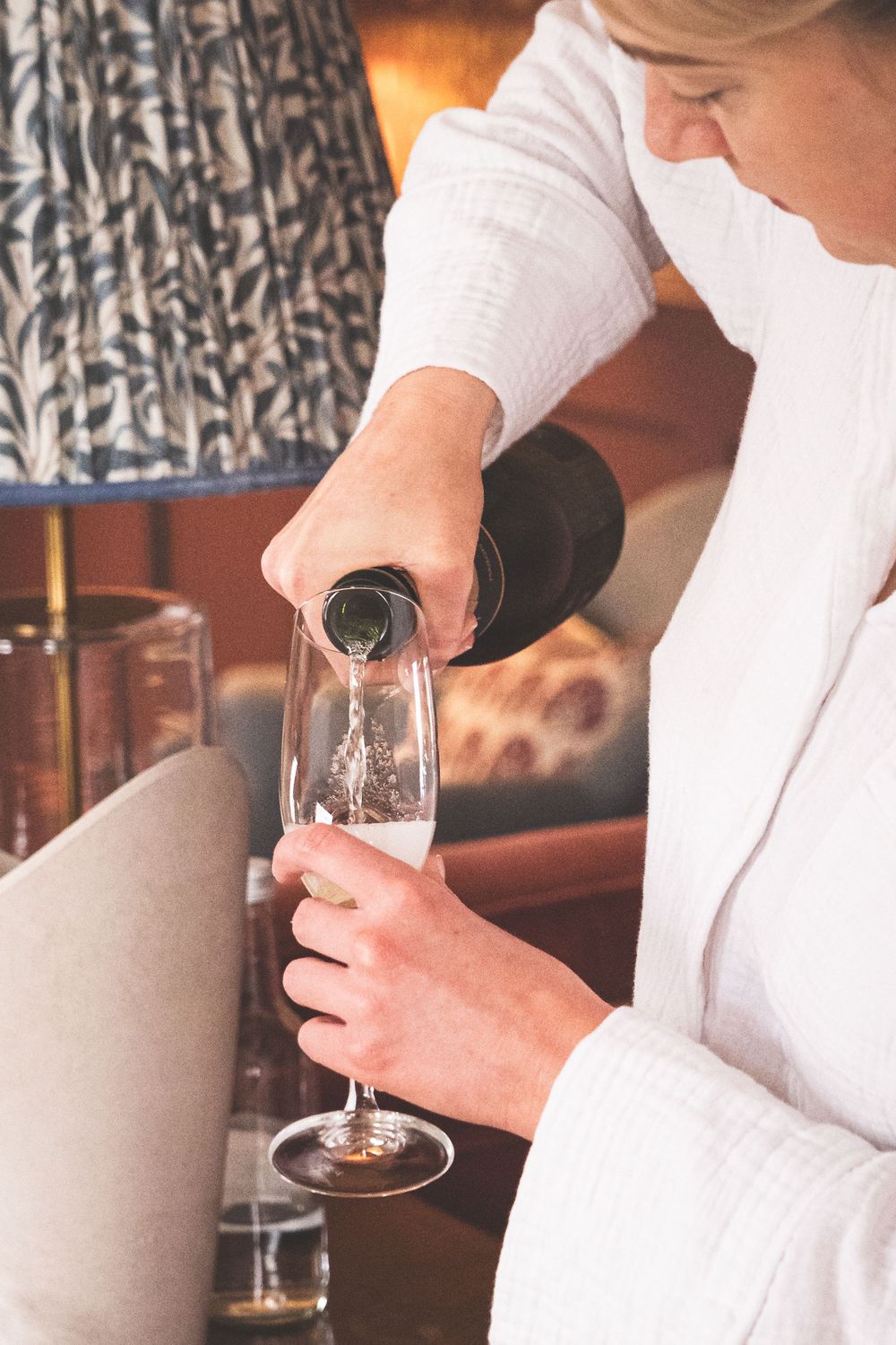 Close-up sequence of hands pouring wine into elegant stemware glasses.