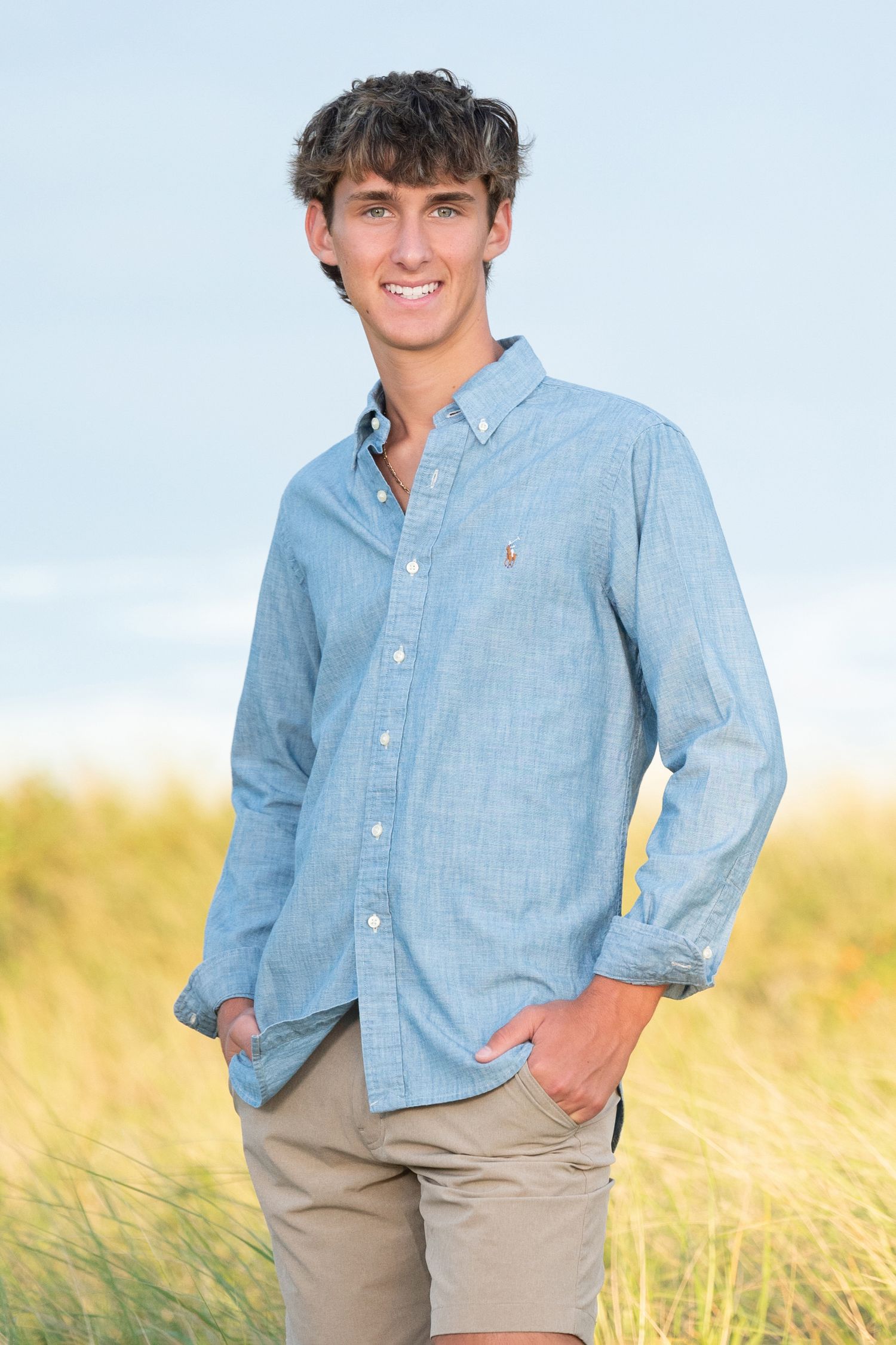 A series of four photos showing someone wearing a green graphic t-shirt and dark pants standing by a river.