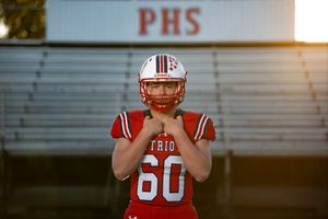 High school football senior portrait in uniform on field in Rhode Island