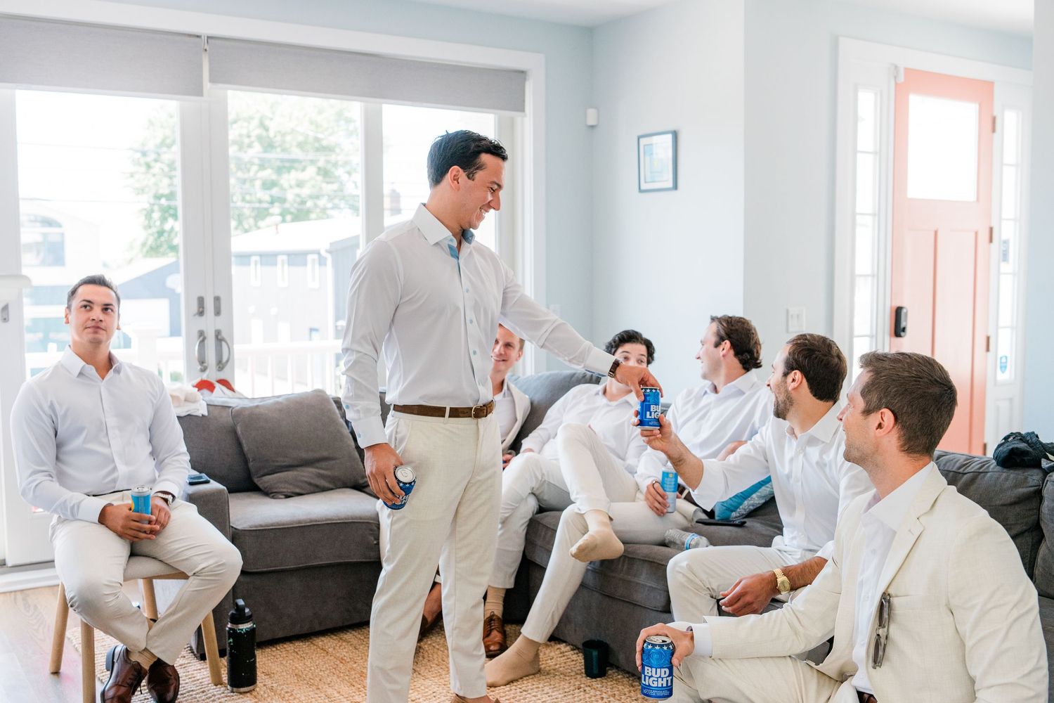 Medical professionals in white coats gather in a modern office setting for a discussion while holding tablets and papers.