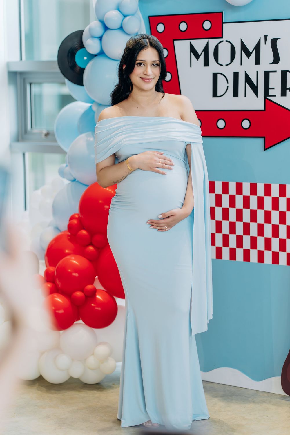 Baby shower setup with Mom's Diner theme featuring balloon decorations and retro diner signage.