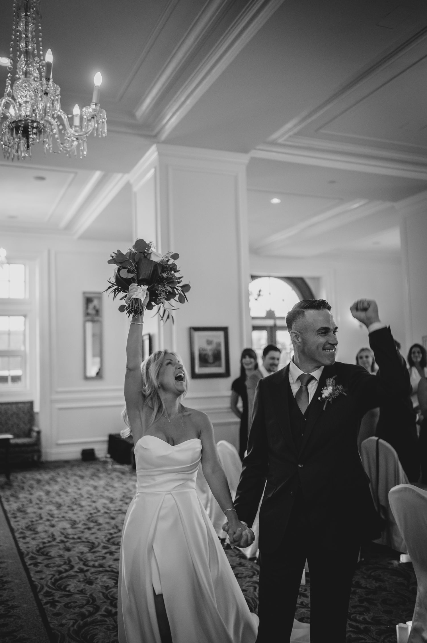 A black and white photo sequence showing guests mingling at an elegant wedding reception with crystal chandeliers.