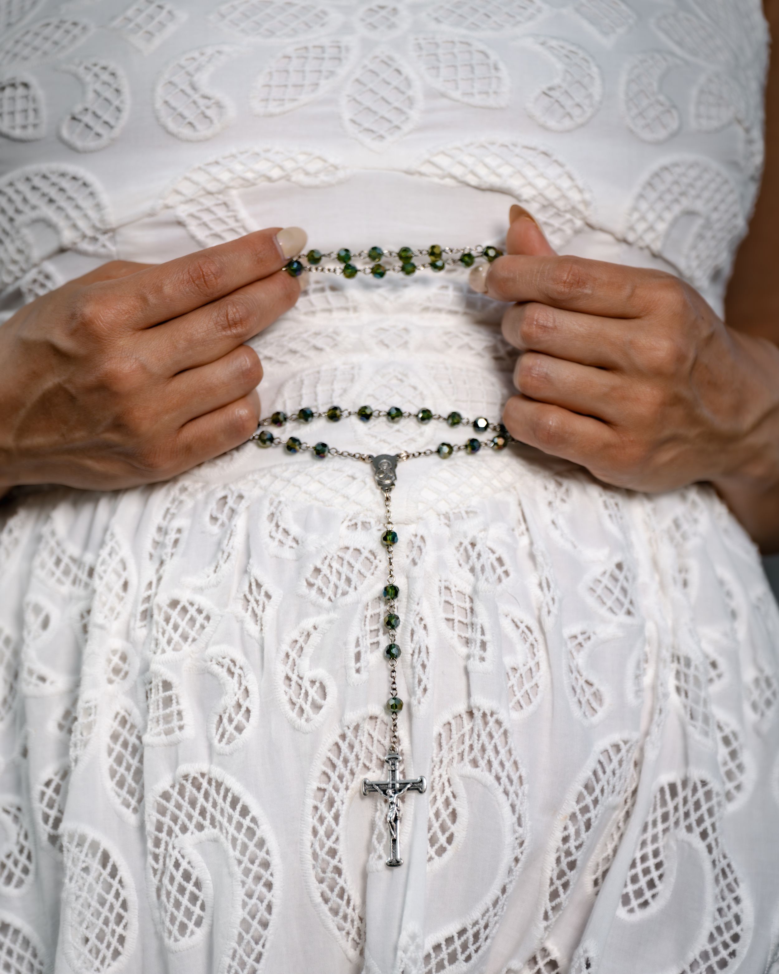 Close-up view of a white lace dress with a beaded chain belt detail showing styling variations.