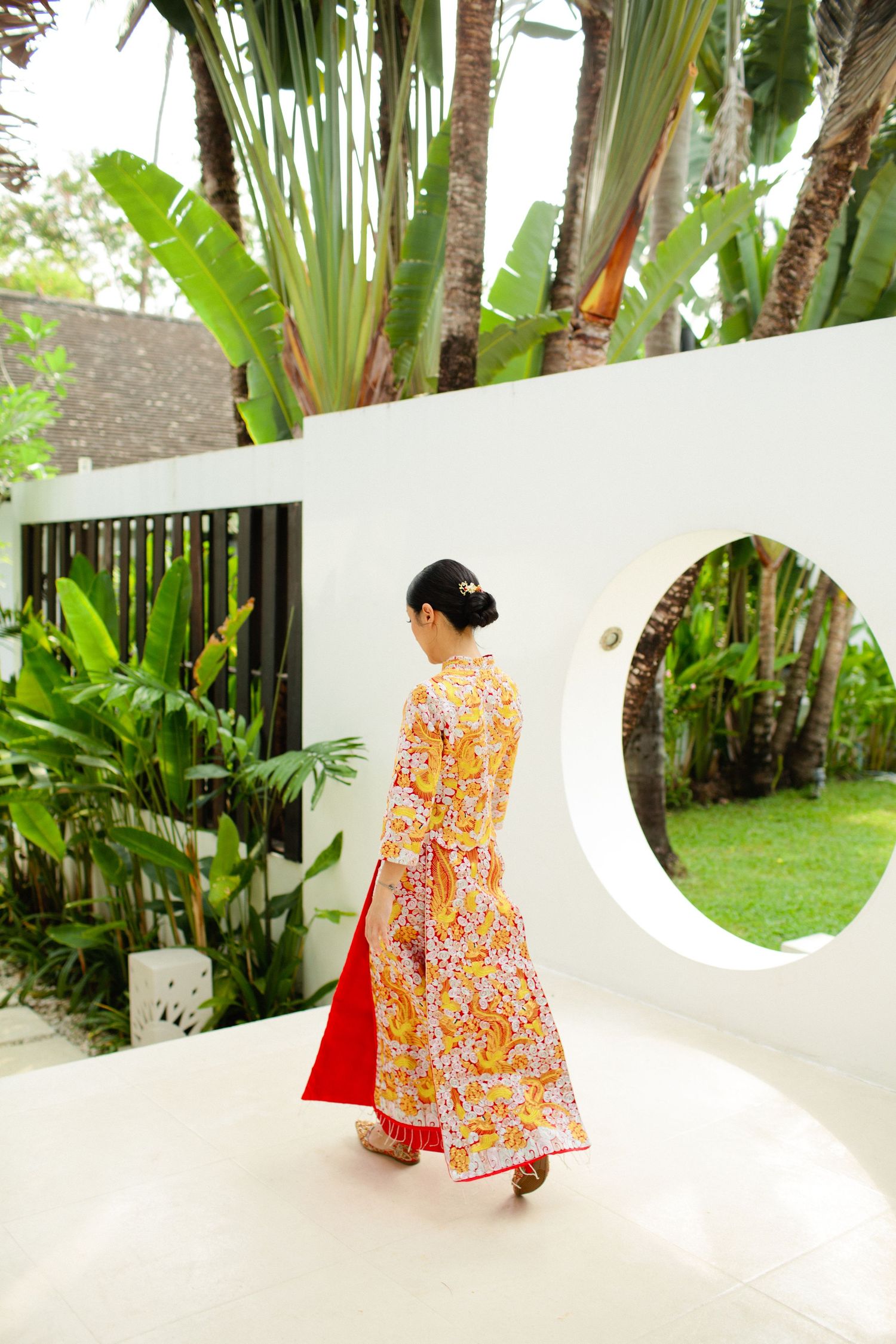 bride in traditional Chinese dress walking through tropical villa garden at Ban Suriya Koh Samui wedding