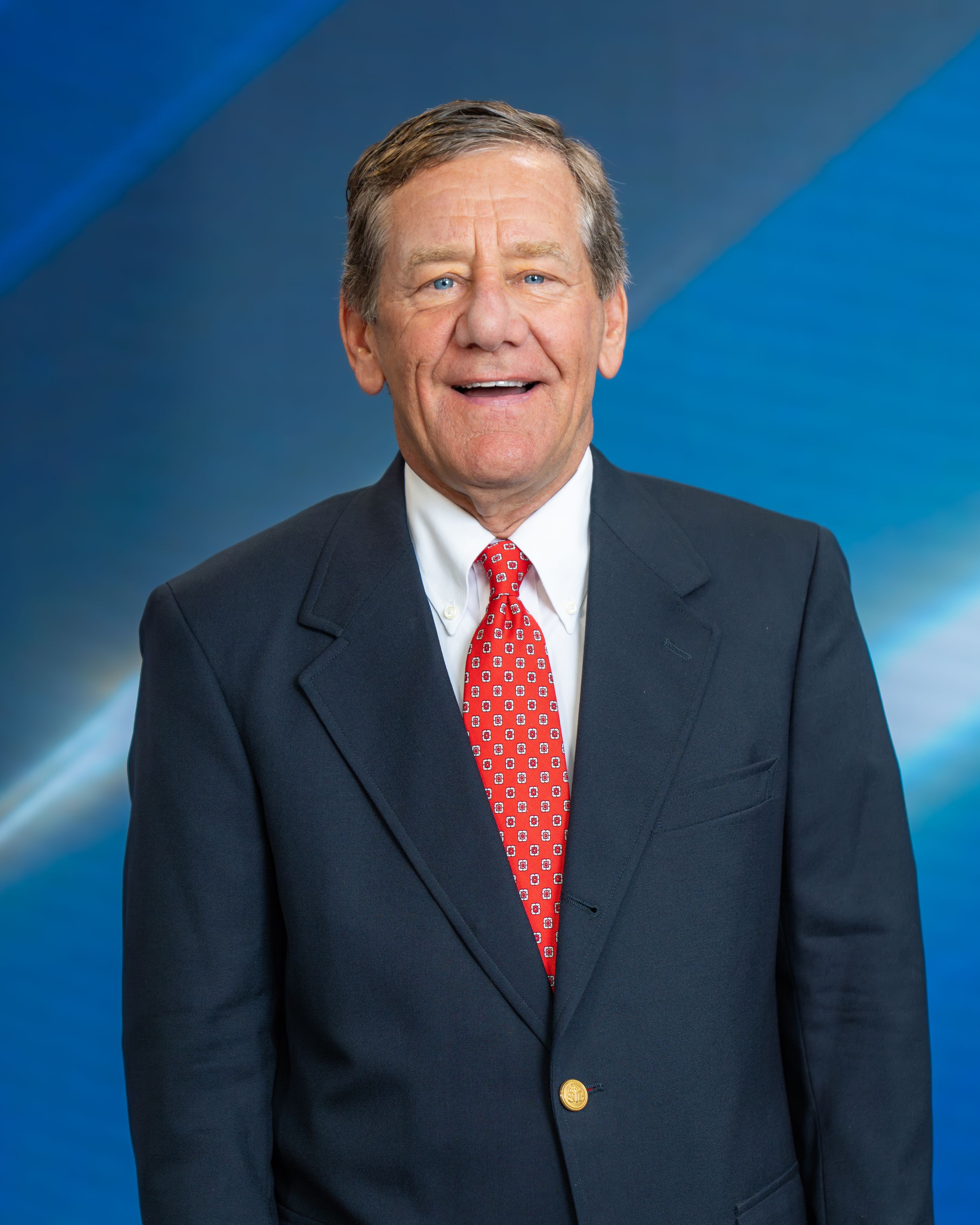 Professional portrait series showing a person in a dark suit and red tie against a blue gradient background.