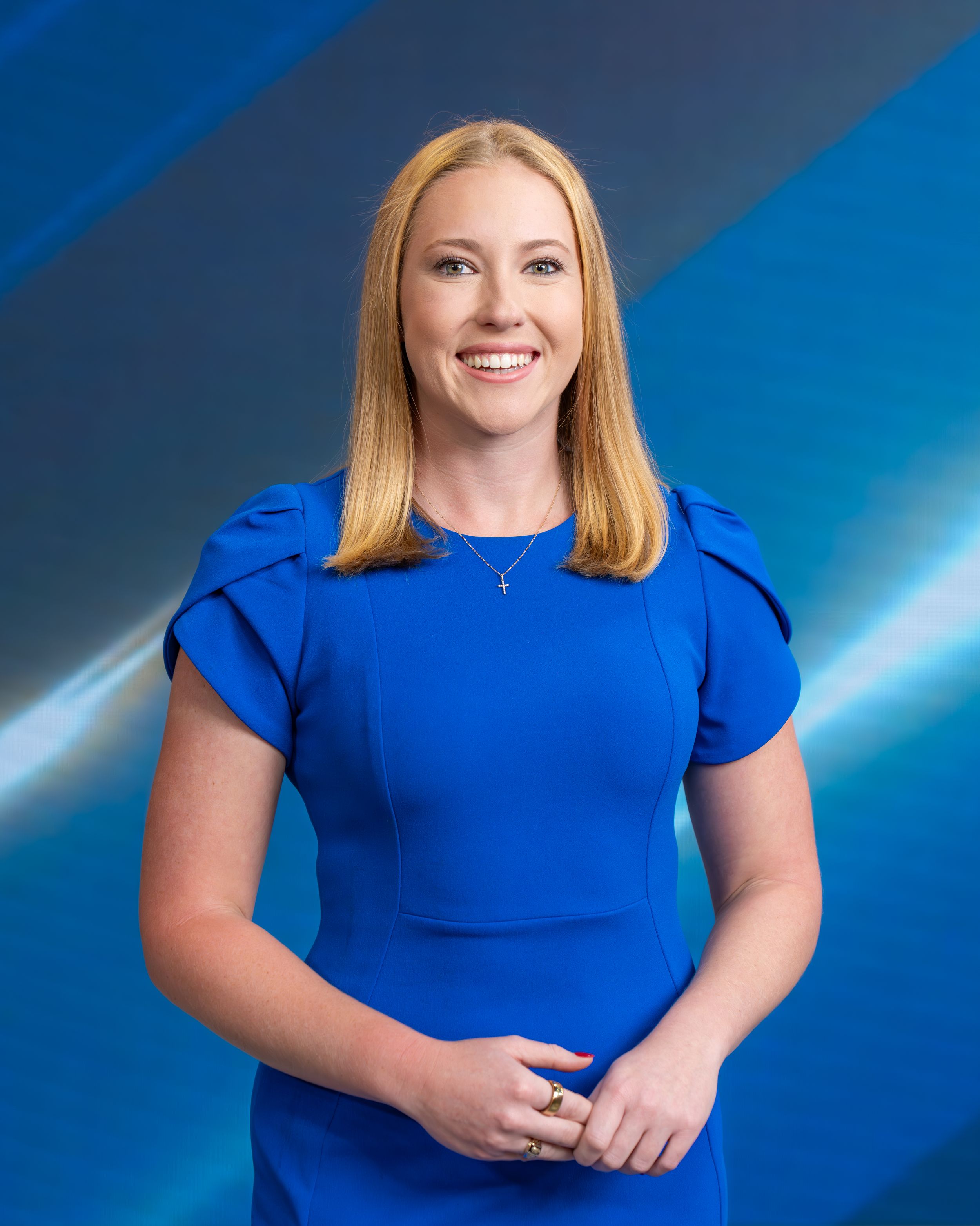 Professional headshot series of a person in a royal blue top against a blue gradient background.