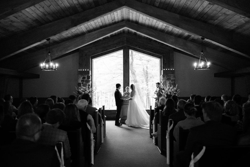 A black and white photo series showing a wedding ceremony in progress inside a rustic wooden church venue.
