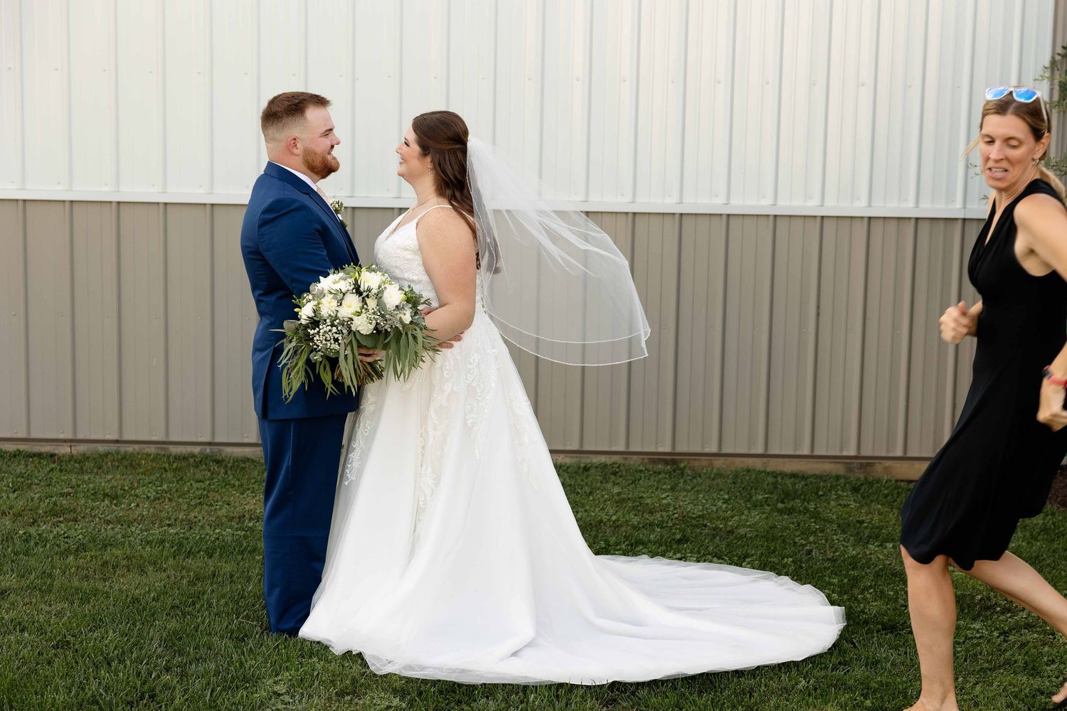 A couple shares a romantic moment during their wedding photoshoot in a backyard garden setting.