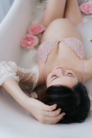 Dreamy boudoir photo with pink roses and soft white fabric.夢幻般的閨房照，粉紅色玫瑰和柔軟的白色布料。