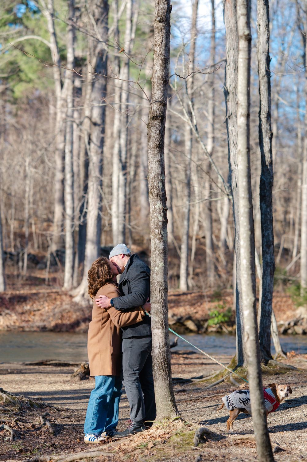 A couple kisses during their proposal on a hike in Westchester in Ward Pound Ridge Reservation.