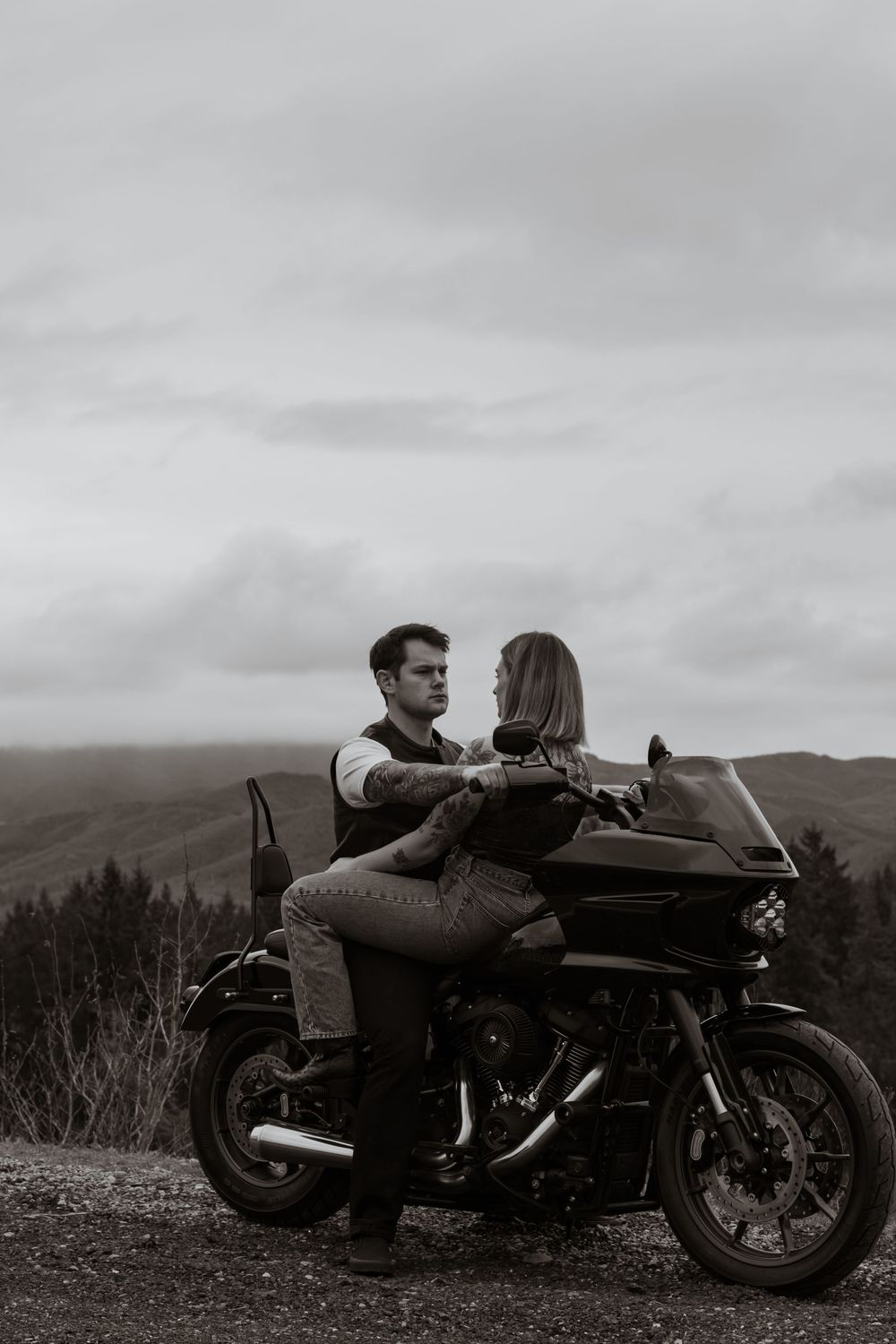 Black and white photo of a couple facing each other intimately while seated on a motorcycle during a photoshoot in yelm washington hills