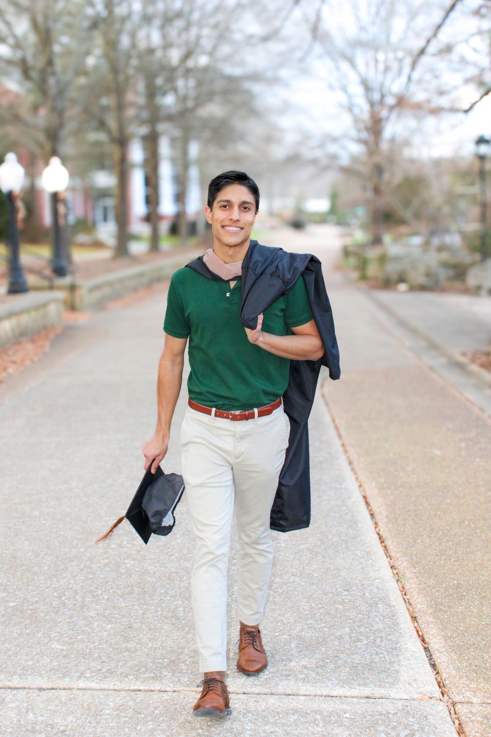 man walking with graduation cape