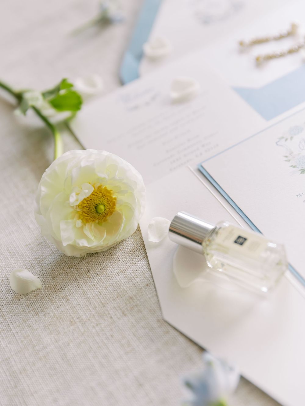 A delicate white poppy flower lies next to a white USB device on a textured linen surface.