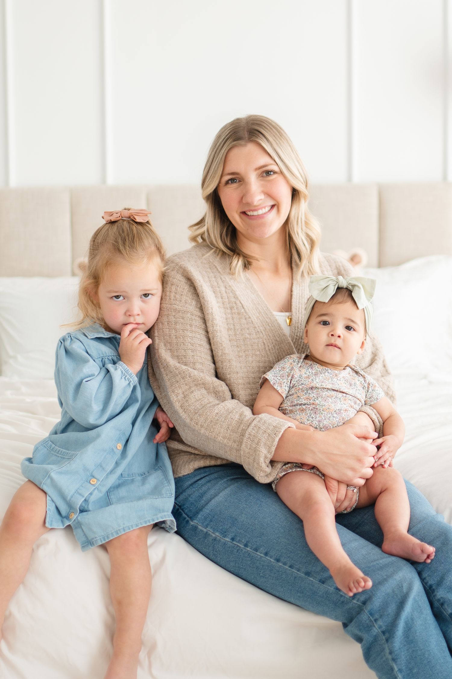 Family portrait on couch showing sweet bonding moment in soft natural lighting.