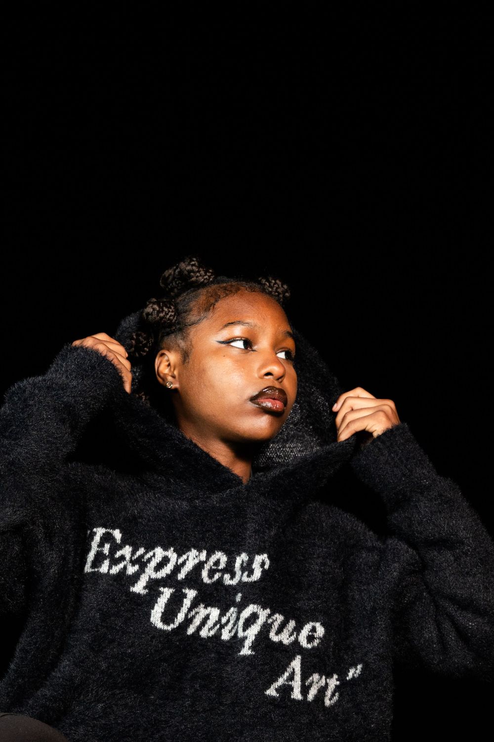 Artistic portrait showcasing black sweater with 'Express Unique Art' text against dark background.