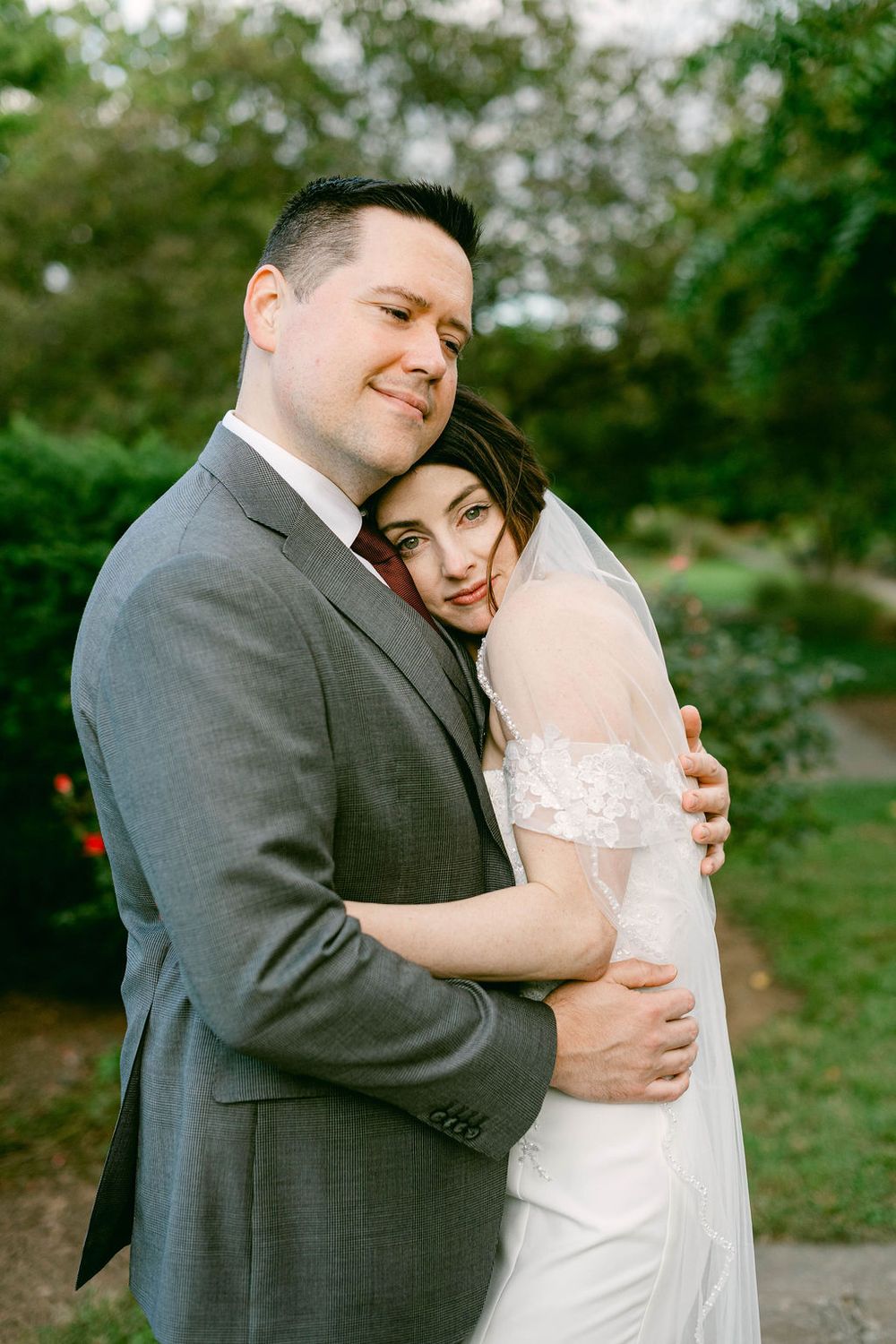 Romantic wedding portraits captured in a garden setting with natural lighting.
