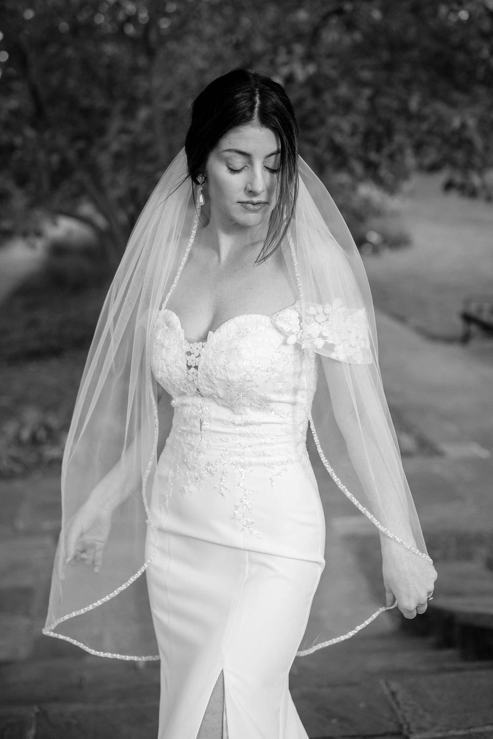 Black and white series showing a bride in a lace wedding gown with delicate veil details.