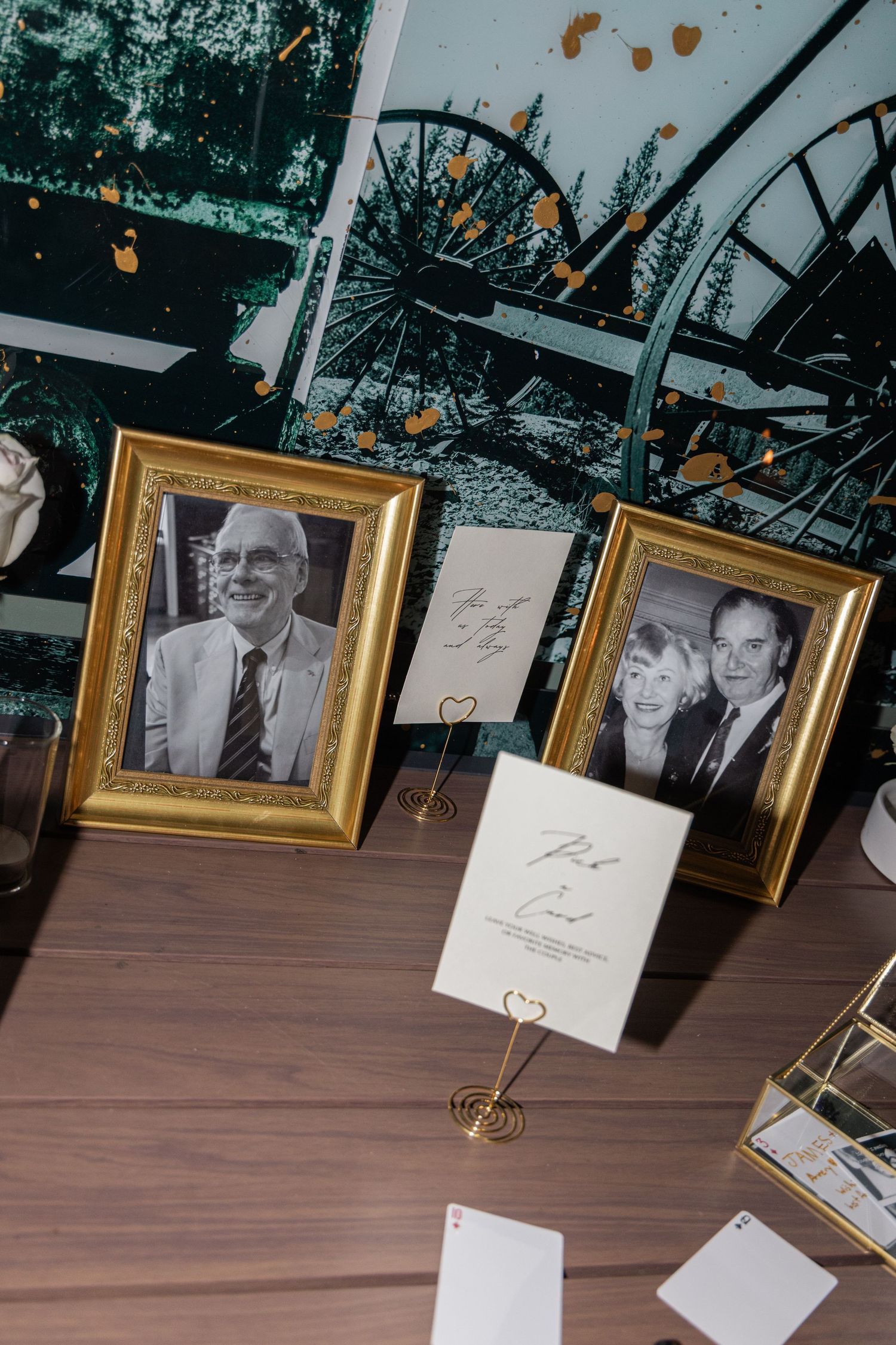 A series of gold-framed photographs arranged in a row on a wooden table surface.