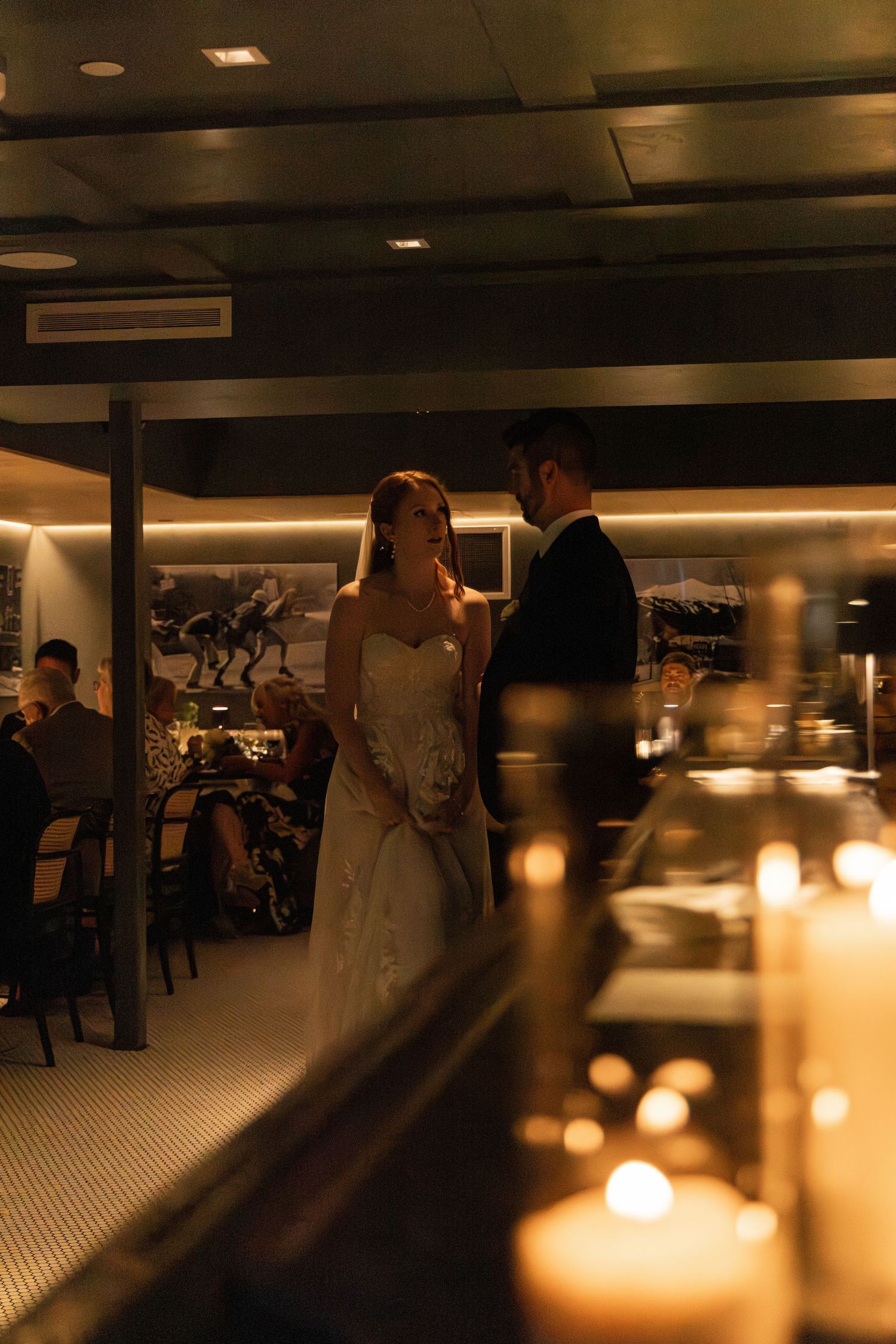 Romantic first dance at a wedding reception with glowing candles in the foreground creating a warm ambiance.
