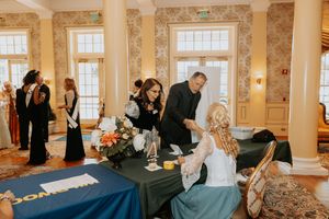 Business professionals raise their hands during an engaging workshop session in a bright, ornate conference room.