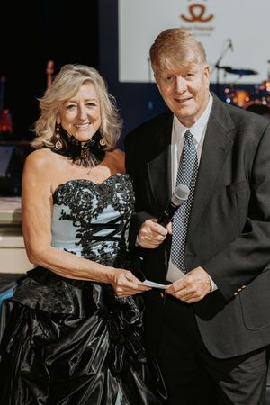 Couple in formal attire dancing at an elegant evening event.