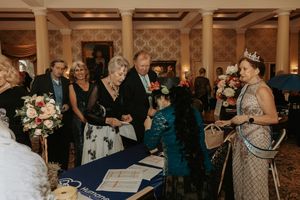 Wedding guests dancing and celebrating together on a dance floor at an elegant indoor reception venue.