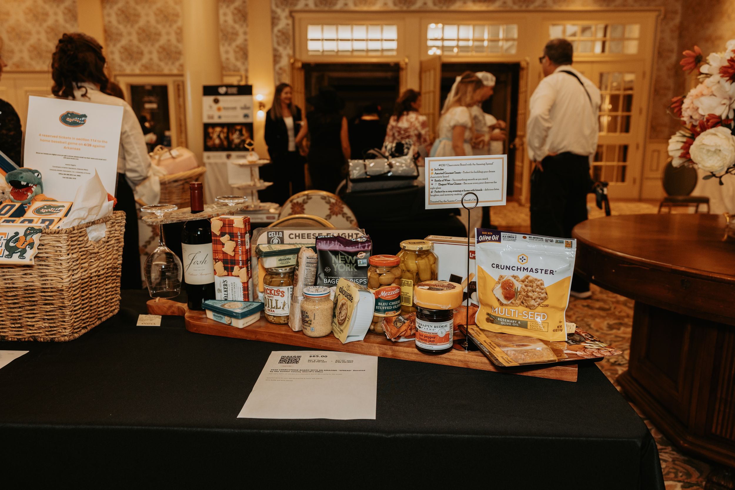 Retail display of gourmet food products and gift baskets arranged on wooden shelves in a specialty store.