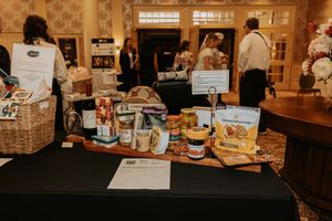 Retail display of gourmet food products and gift baskets arranged on wooden shelves in a specialty store.