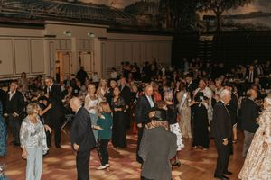 Wide shot of a formal event ballroom with guests mingling on the dance floor.