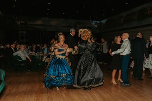Guests in formal attire dancing and socializing at an evening event.