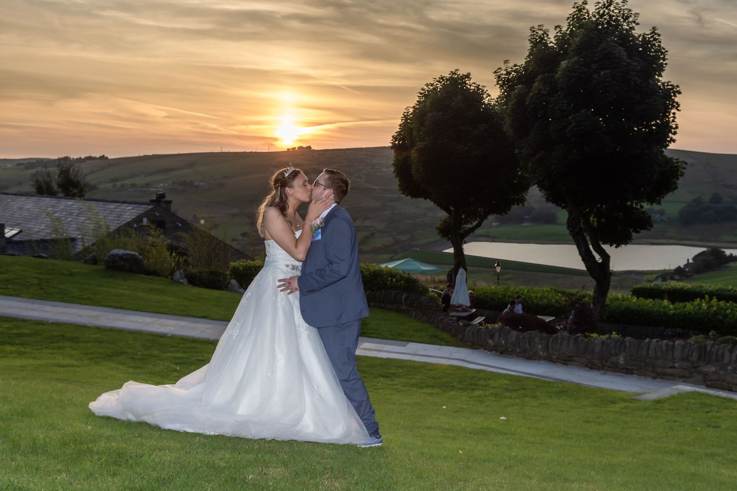 A bride and groom kissing each other during a sunset wedding photograph at Saddleworth Hotel by Michael Pardoe, wedding photographer.