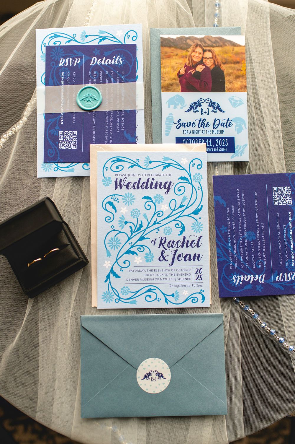 Wedding invitation suite featuring navy blue and light blue designs with elegant swirls and QR codes on white cards.