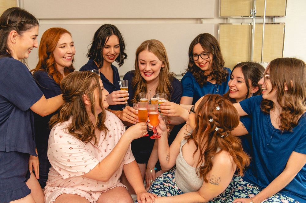 A group of friends laughing and enjoying drinks together at a social gathering.