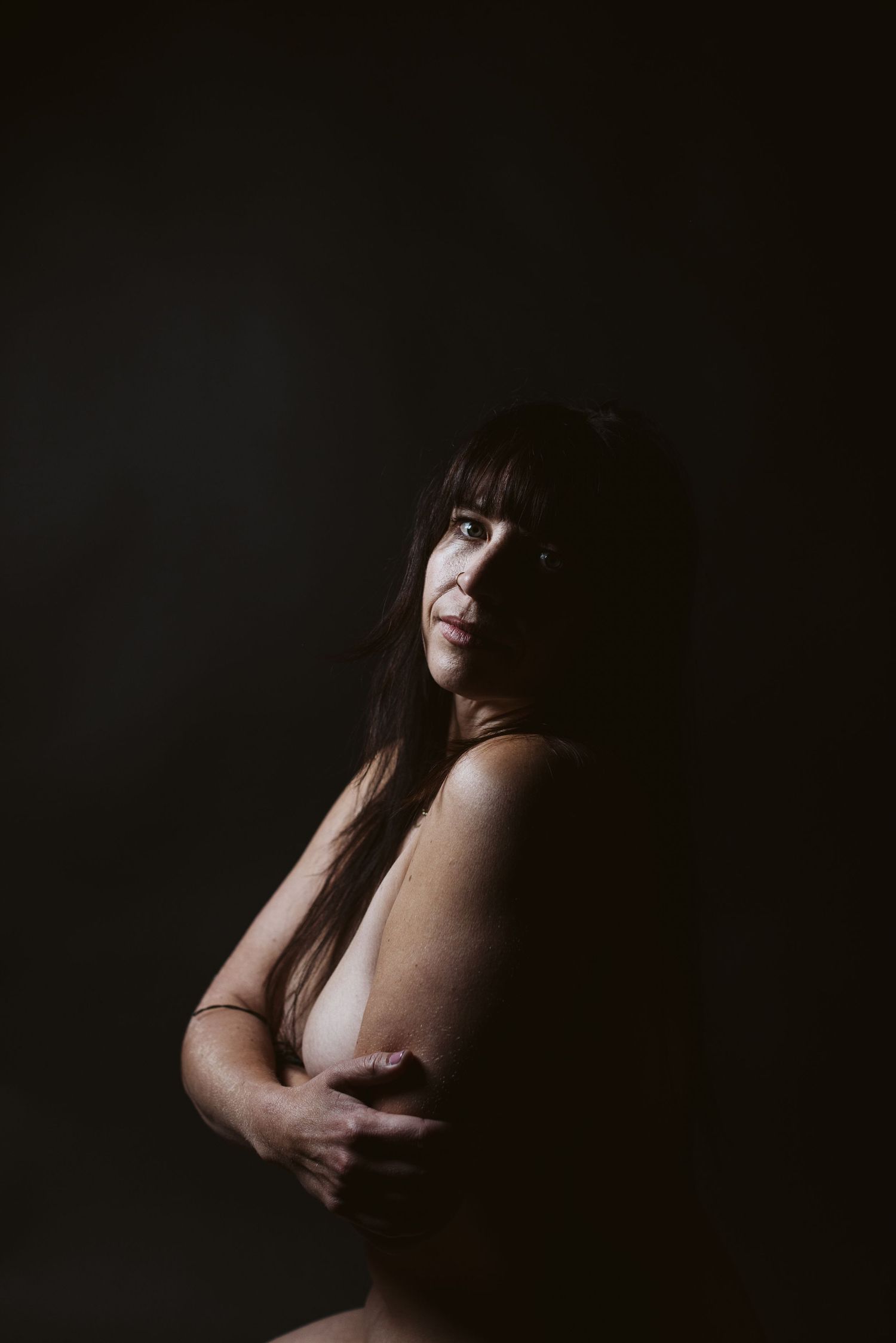 Artistic dark and moody portrait photography with dramatic shadows and lighting.