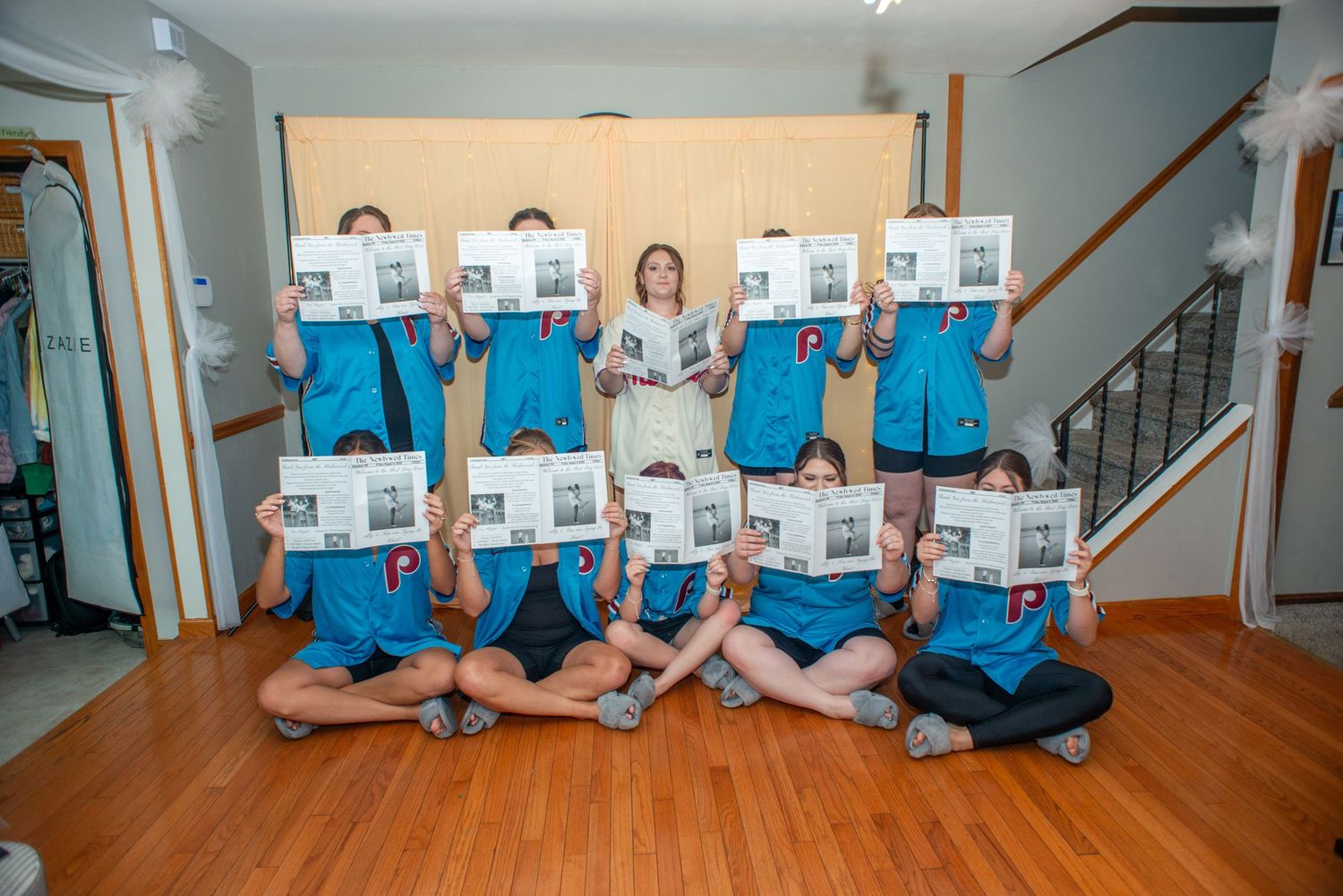 A creative photo series showing people holding white papers while sitting on wooden stairs in matching blue shirts.