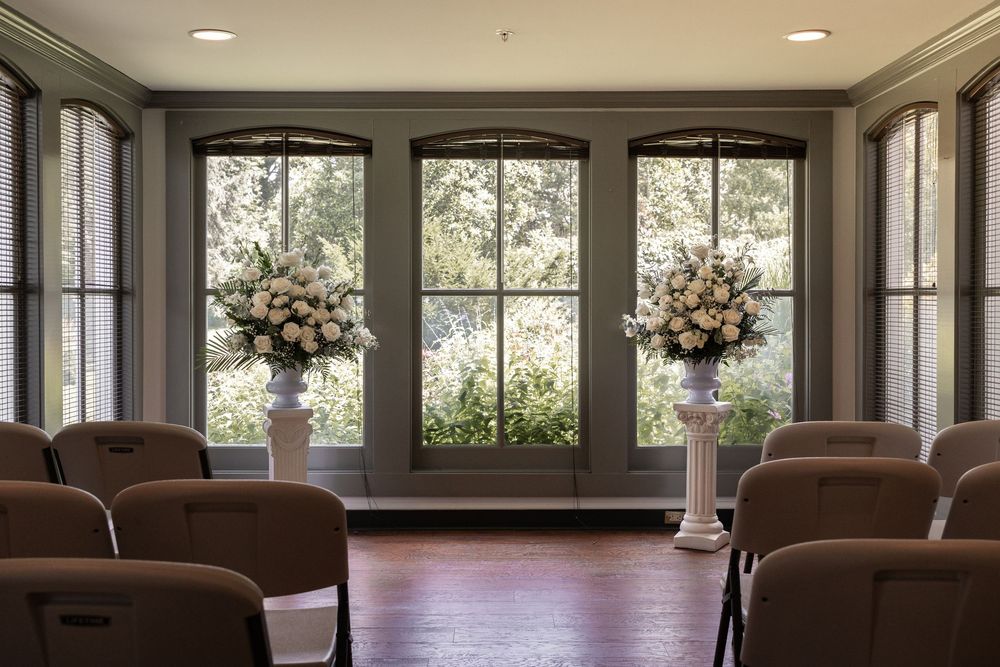 Elegant event space interior with arched windows, recessed lighting, and dark brown leather seating along the walls.
