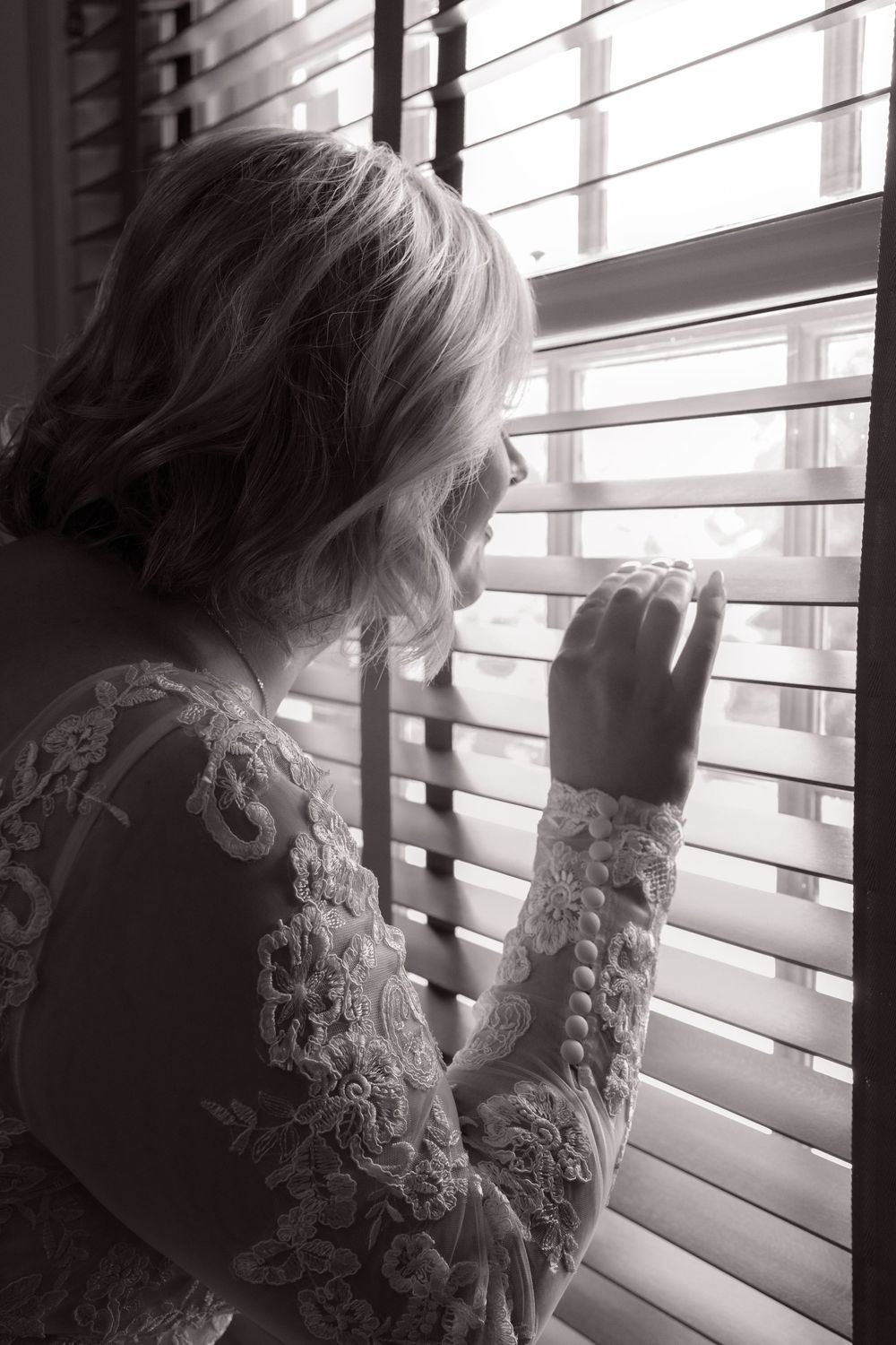 A series of black and white photos showing someone looking through window blinds in dramatic lighting.